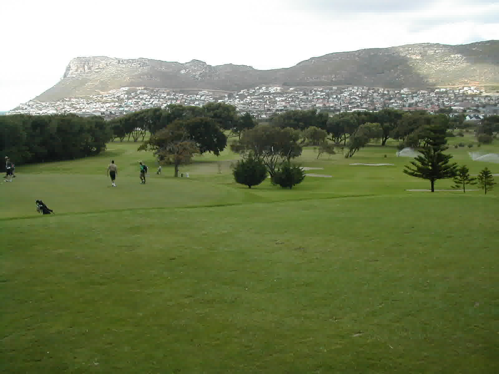 Golfers on a South African fairway with mountains behind